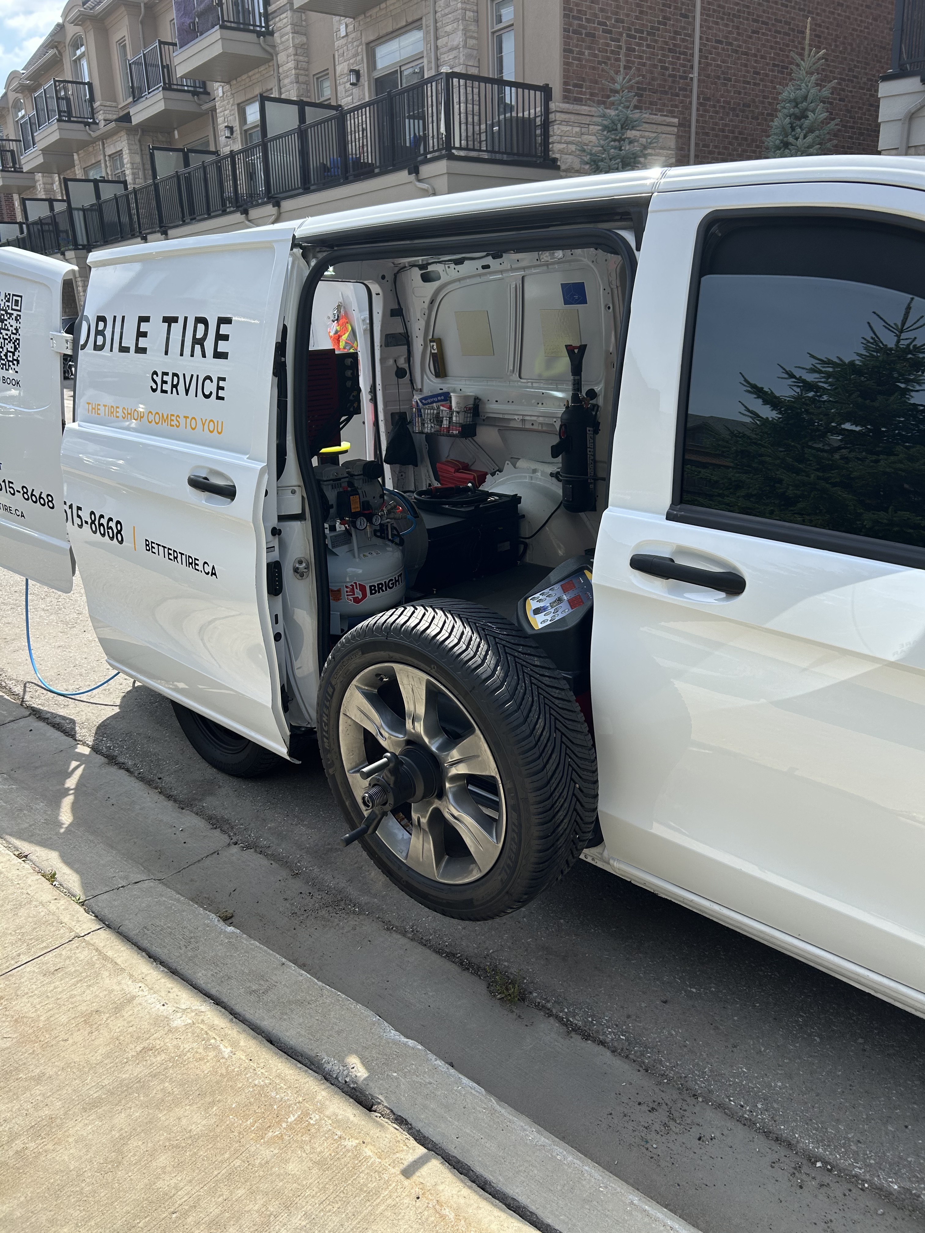 Wheel and tire mounted on the balancer at the side of the Better Tire service van