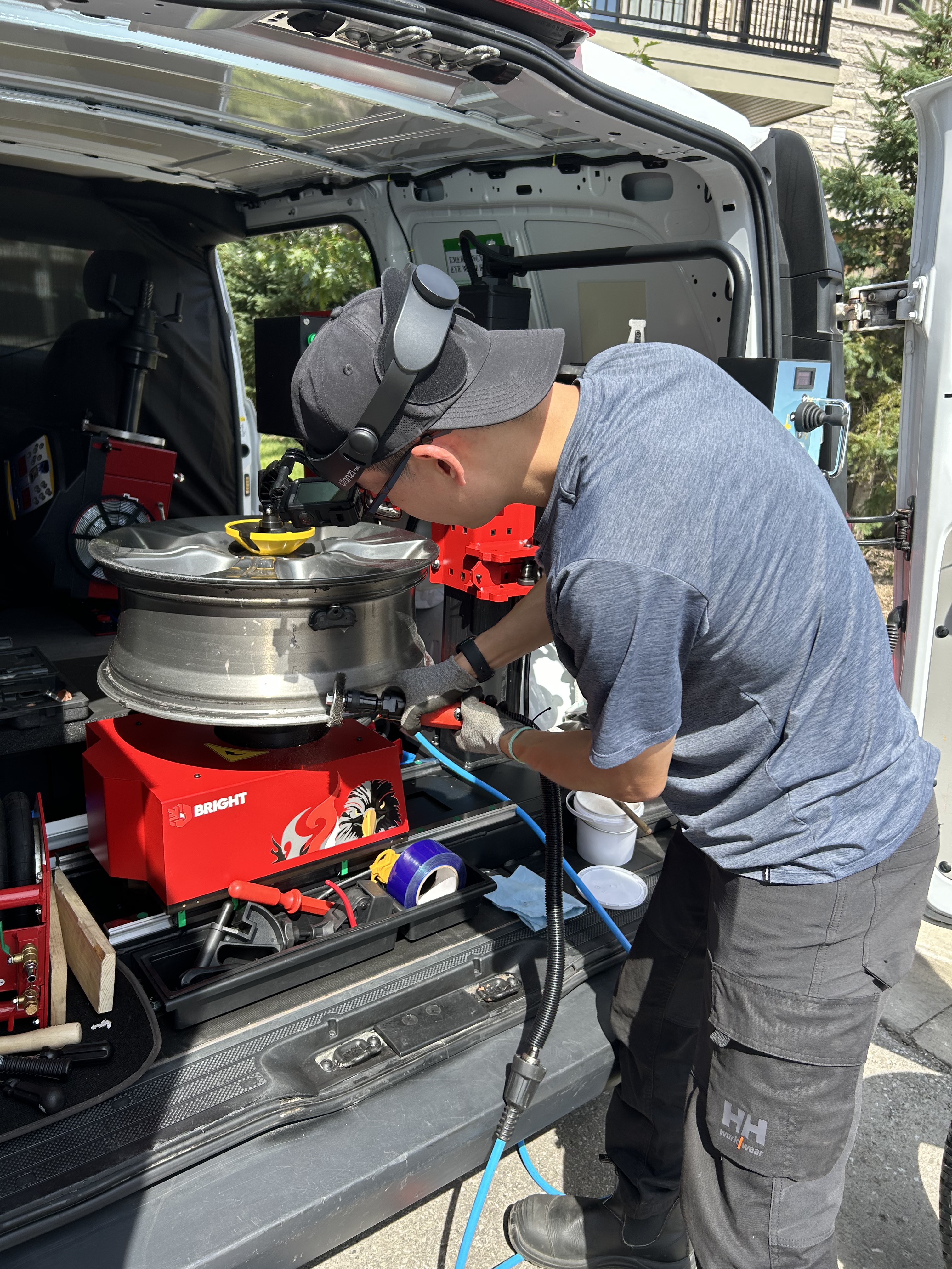 Technician working on a wheel at the rear of the Better Tire van